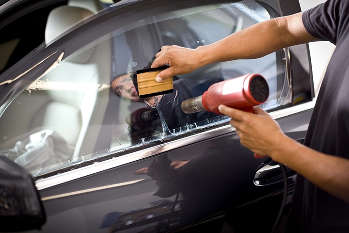 Man installing film on a car window